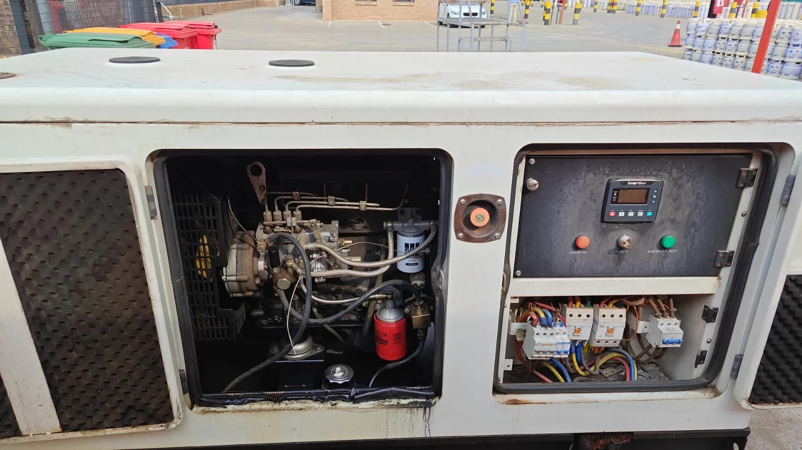 Cream canopy open on a diesel engine, SmartGen controller and wired breaker panel, gas cylinders stacked behind