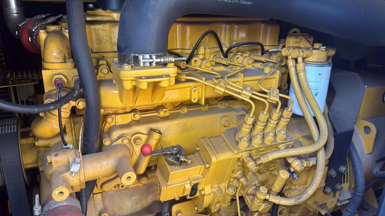 Yellow four-cylinder diesel engine with injection pump, high-pressure fuel lines and a spin-on fuel filter
