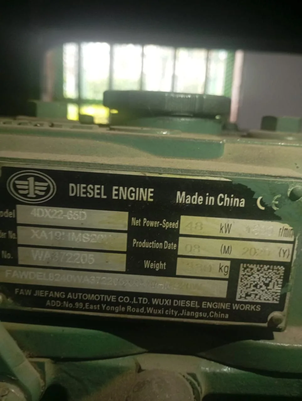 FAW diesel engine data plate showing model 4DX22-65D, serial number and production date on a green engine block