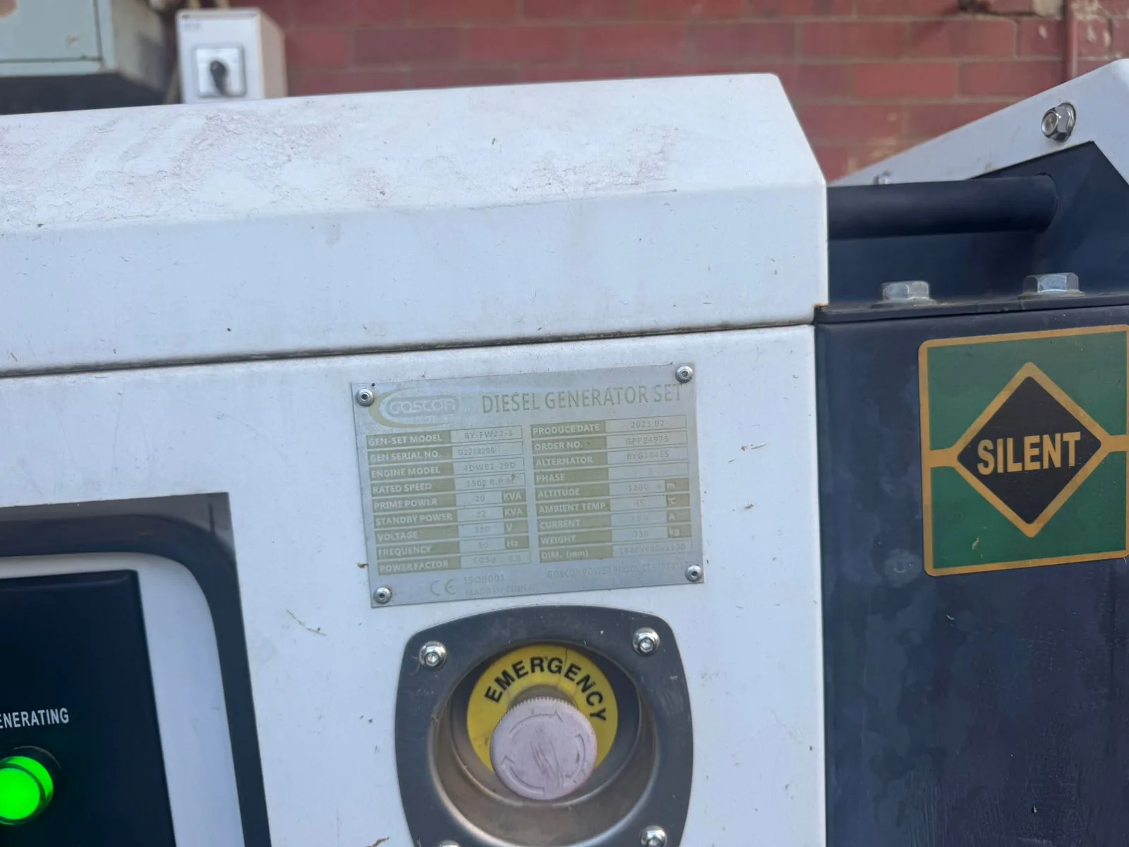 Gosco diesel generator set rating plate listing 20/22 kVA, 380 V and 1500 rpm beside a yellow emergency stop