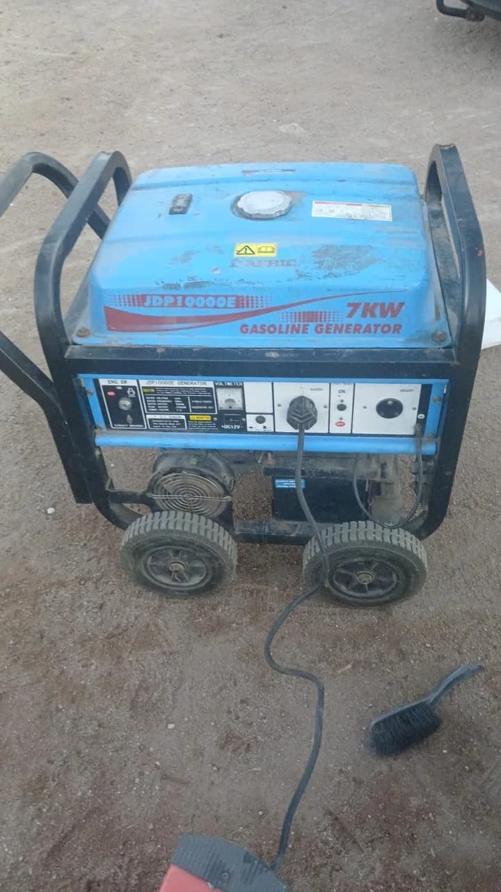 Blue Mac Afric JDP10000E 7 kW petrol generator on wheels, plugged in on a bare concrete floor